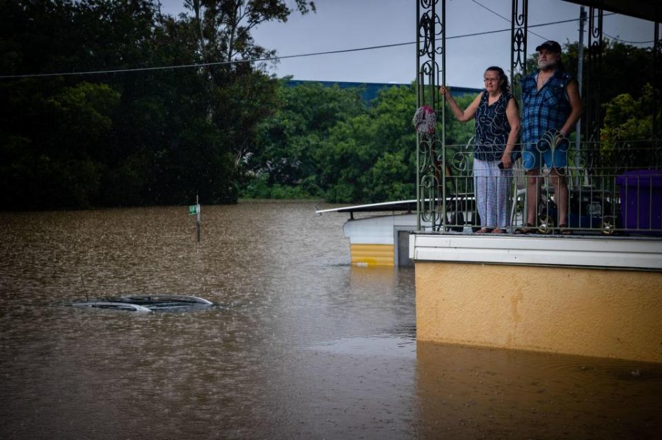 Residents look at floodwaters from the balcony of their home in West Ipswich on February 26. Source: Getty