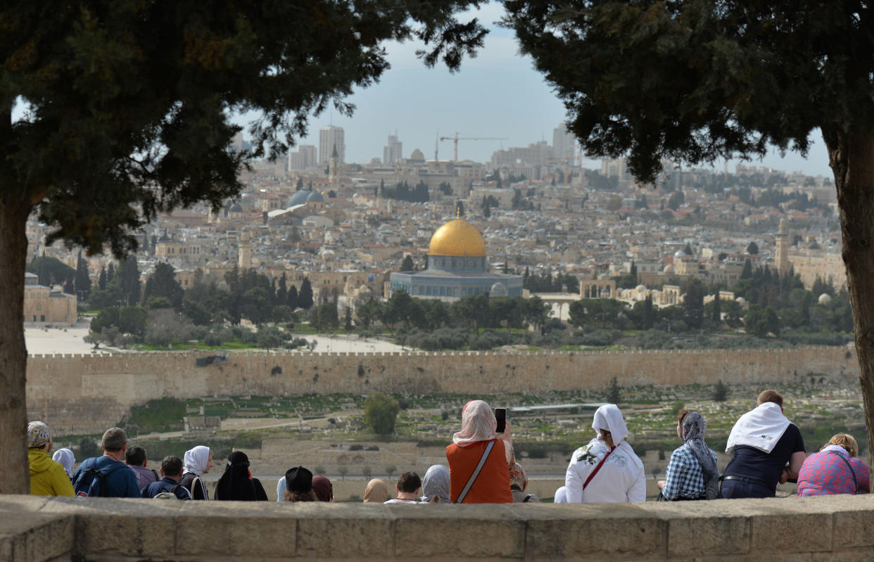 Tourists look from the Mount of Olives at the Old City of Jerusalem.