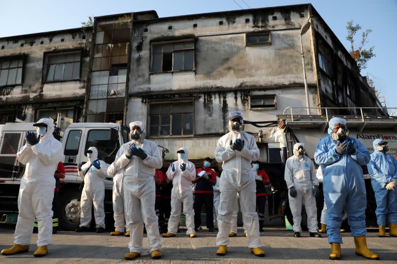 Workers wearing protective suits pray before a disinfection operation, during the movement control order due to the outbreak of the coronavirus disease (COVID-19), in Kuala Lumpur