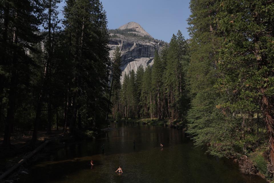 Yosemite National Park visitors wade in a river on July 12, 2022 in Yosemite National Park, California.