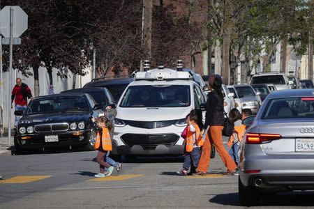 Children pass by a self-driving GM Bolt EV during a media event in San Francisco, California, U.S. November 28, 2017. REUTERS/Elijah Nouvelage