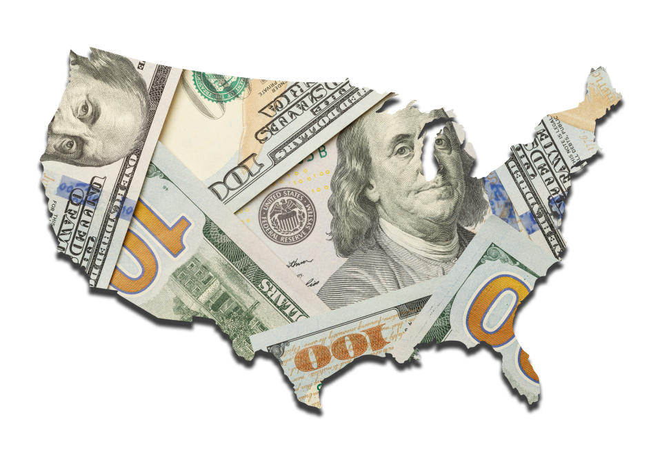 An outline of the United States that's filled in with a messy pile of hundred dollar bills.