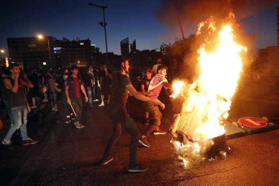 Anti-government protesters burn barriers to block a road during a protest against the political leadership they blame for the economic and financial crisis, in front of the government house in downtown Beirut, Lebanon, Thursday, June 11, 2020. (AP Photo / Hussein Malla)