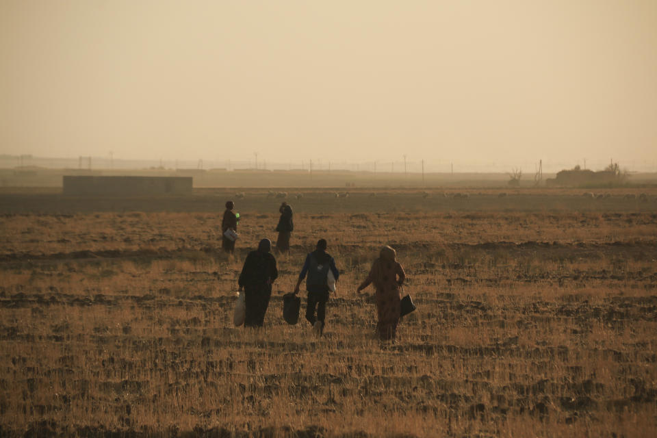 Syrians flee shelling by Turkish forces in Ras al Ayn, northeast Syria, Wednesday, Oct. 9, 2019. Turkish President Recep Tayyip Erdogan announced Wednesday the start of a Turkish military operation against Kurdish fighters in northeastern Syria. (AP Photo/Baderkhan Ahmad)