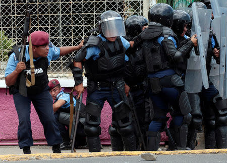 Riot policemen take cover during clashes with university students protesting over a controversial reform to the pension plans of the Nicaraguan Social Security Institute (INSS) in Managua, Nicaragua April 20, 2018. REUTERS/Oswaldo Rivas