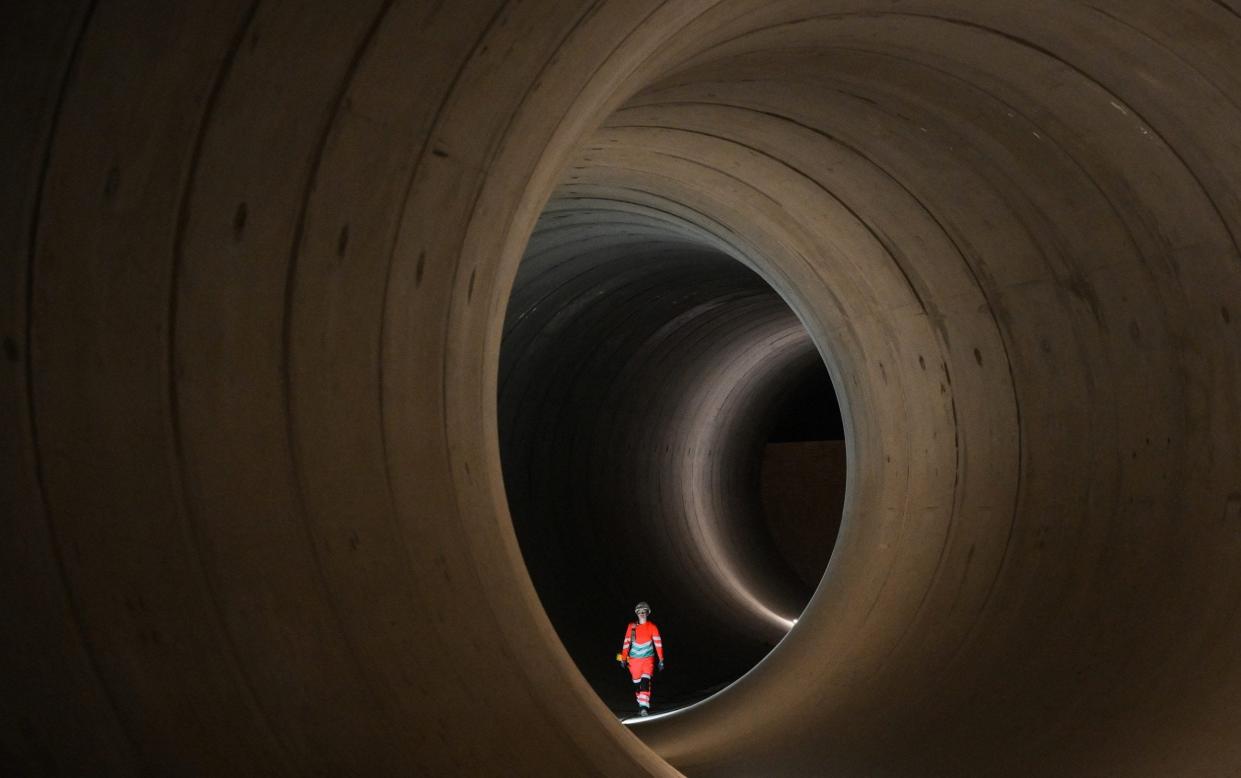 A civil engineer walks inside a 7 metre concrete tunnel at the Thames Tideway building site, in west London, on June 14, 2023. London's existing sewerage network dates back to the second half of the 1800s. With the size of the population set to continue to swell, the need for the Â£4.3-billion ($5.6-billion) upgrade has become critical.