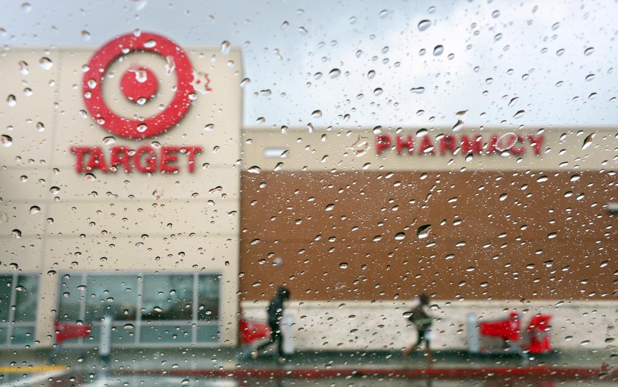 A couple of shoppers leave a Target store on a rainy afternoon in Alhambra, California on December19, 2013. (FREDERIC J. BROWN/AFP via Getty Images)