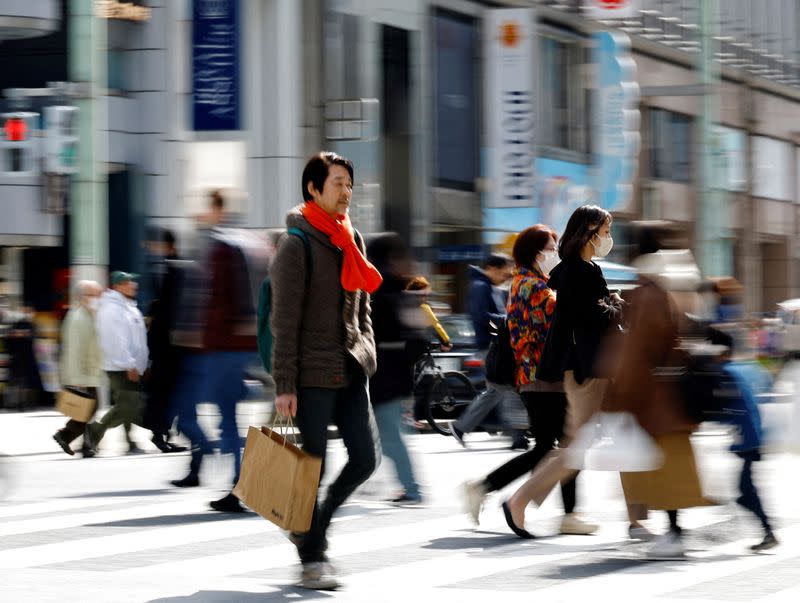 FILE PHOTO: Shoppers make their way at a shopping district in Tokyo