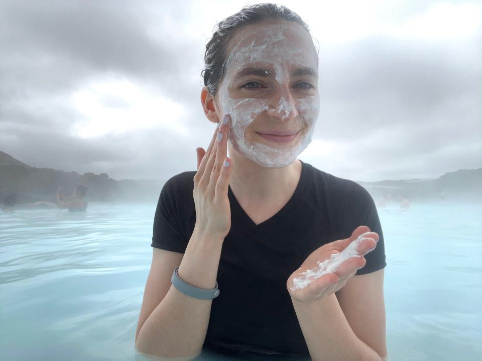 The author puts white mud on her face at the Blue Lagoon in Iceland.