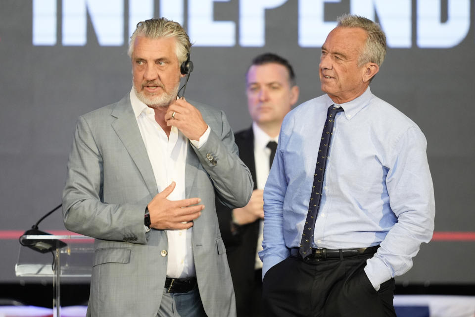 Presidential candidate Robert F. Kennedy Jr., right, stands on the stage before a campaign event where he is expected to announce a running mate, Tuesday, March 26, 2024, in Oakland, Calif. (AP Photo/Eric Risberg)