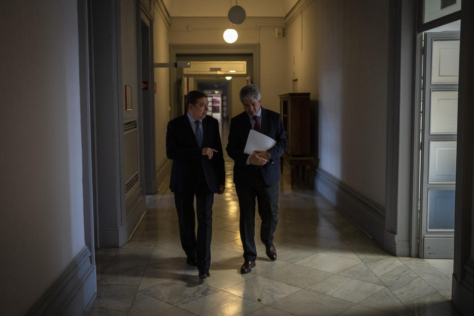 Spain's Agriculture Minister Luis Planas Puchades, left, walks inside the Minister of Agriculture, Fisheries and Food in Madrid, Wednesday, Nov. 2, 2022. “Our forecast for this harvest season is notoriously low,” he said. (AP Photo/Bernat Armangue)