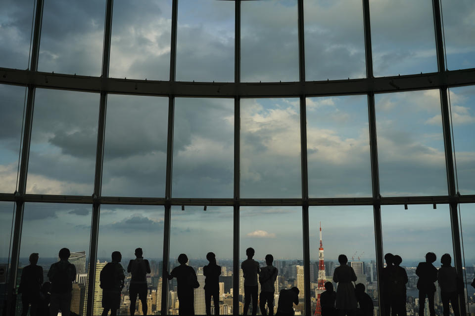 Visitors are silhouetted against a floor-to-ceiling window as they view Tokyo's skyline from an observation deck located on the top floor of Roppongi Hills Mori Tower, Thursday, Sept. 19, 2019, in Tokyo. (AP Photo/Jae C. Hong)