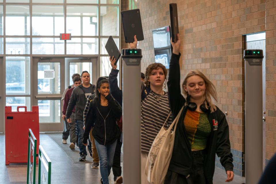Students and faculty demonstrate the new metal detectors specialized with technology to recognize weapons Friday, Feb. 2, 2024, at Lawrence North High School in Indianapolis. Due to a type of metal in Chromebook laptops matching the metal of some firearms, students are asked to lift their laptops above the machine when they walk into the building. These metal detectors were implemented across Lawrence Township’s secondary schools.