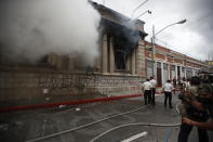 Clouds of smoke shoot out from the Congress building after protesters set a part of the building on fire, in Guatemala City, Saturday, Nov. 21, 2020. Hundreds of protesters were protesting in various parts of the country Saturday against Guatemalan President Alejandro Giammattei and members of Congress for the approval of the 2021 budget that reduced funds for education, health and the fight for human rights. (AP Photo/Moises Castillo)