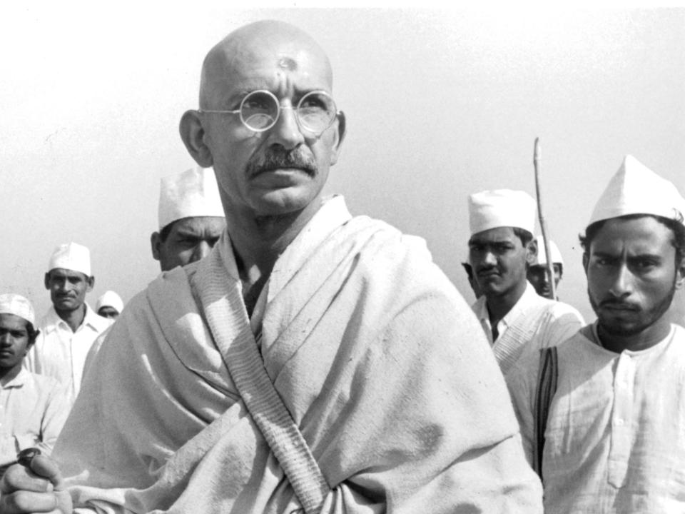 Ben Kingsley as gahndi with men standing behind him