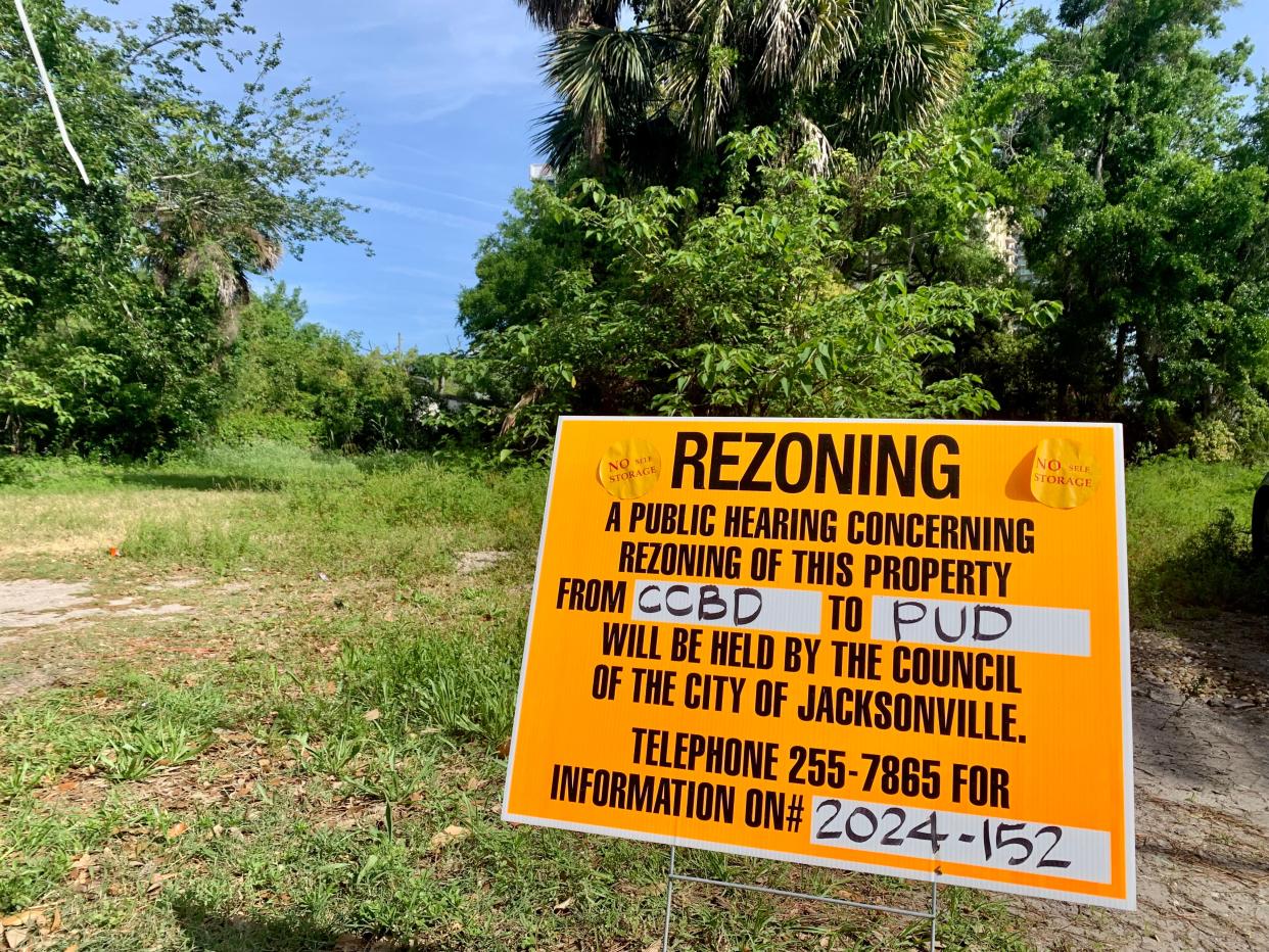 A sign about the potential rezoning of property for a 10-story Vesctor building on the downtown Southbank stands off Home Street on the backside of the property that is mostly vacant space with some woods. Opponents of rezoning put "No Self Storage" stickers on the sign.