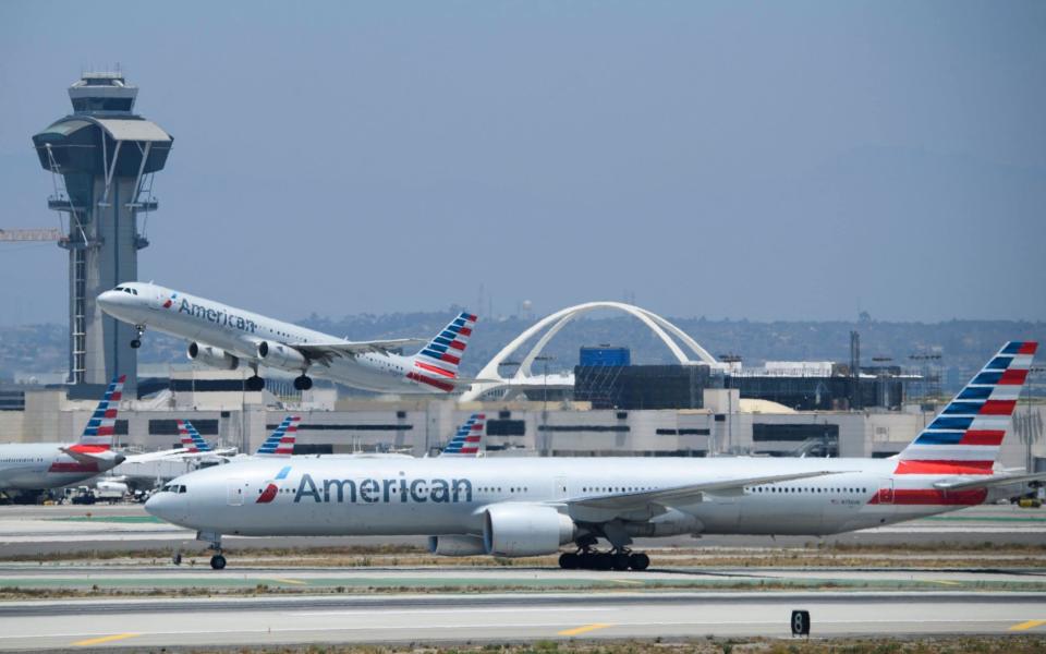 An American Airlines, Inc. Airbus SE A321 aircraft takes off as a Boeing Co. 777-300ER taxis on the tarmac at Los Angeles International Airport (LAX) on July 6, 2021 in Los Angeles, California. - The LAX airport celebrates 60 years since the opening of the "Jet Age" terminals and Theme Building as a $14.5 billion airport infrastructure modernization and transit construction project continues ahead of the 2028 Los Angeles Olympics. - AFP