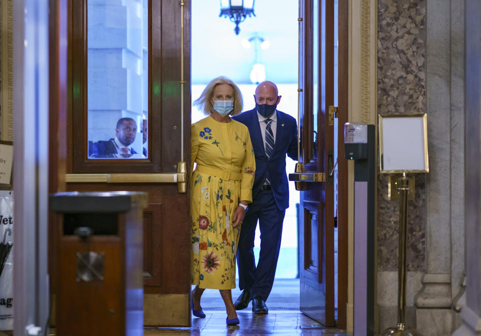 Sen. Mark Kelly, D-Ariz., is joined by Cindy McCain, left, the widow of the late Senator John McCain of Arizona, as Kelly arrives to deliver his maiden speech to the Senate, at the Capitol in Washington, Wednesday, Aug. 4, 2021. (AP Photo/J. Scott Applewhite)