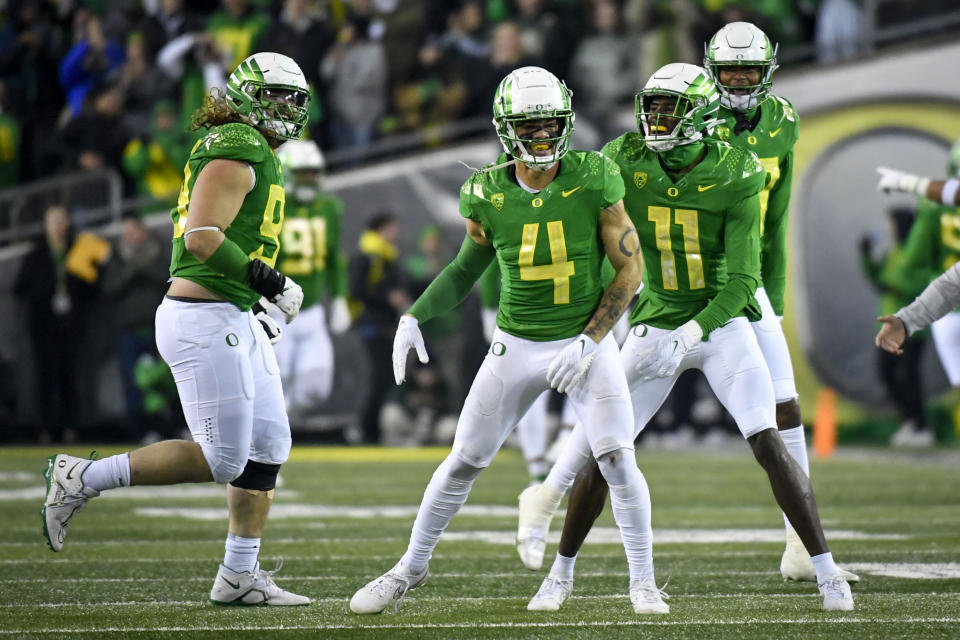 Oregon defensive back Bennett Williams (4) celebrates an interception against Utah with defensive lineman Casey Rogers, left, and defensive back Trikweze Bridges (11) during the first half of an NCAA college football game Saturday, Nov. 19, 2022, in Eugene, Ore. (AP Photo/Andy Nelson)