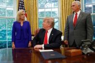 U.S. President Donald Trump looks back at DHS Secretary Kirstjen Nielsen as he prepares to sign an executive order on immigration policy with Vice President Mike Pence at his side in the Oval Office at the White House in Washington, U.S., June 20, 2018. REUTERS/Leah Millis