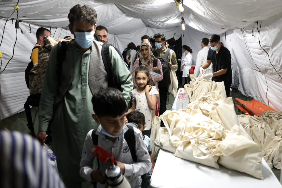 Evacuated citizens from Afghanistan arrive at Tirana International Airport in Tirana, Albania, Friday, Aug. 27, 2021. A government decision has planned that the Afghans may stay at least a year during which they will proceed with their application for special visas before they move on to the U.S. for final settlement. (AP Photo/Franc Zhurda)