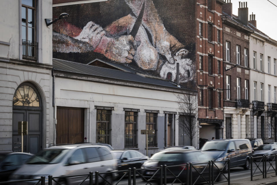 FILE - In this Jan. 26, 2017 file photo, a wall mural of a struggling child with a knife to his neck is painted on the wall of a house in Brussels. Painted by an anonymous street artist, it depicts details from Caravaggio and Dutch Master paintings. The debate is still continuing over whether to paint over the mural. (AP Photo/Geert Vanden Wijngaert, File)