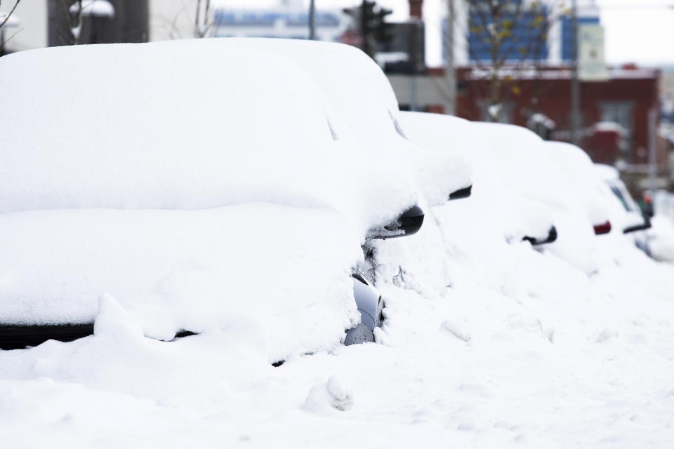 Cars covered in snow are seen downtown Friday, Nov. 18, 2022, in Buffalo, N.Y. A dangerous lake-effect snowstorm paralyzed parts of western and northern New York, with nearly 2 feet of snow already on the ground in some places and possibly much more on the way. (AP Photo/Joshua Bessex)
