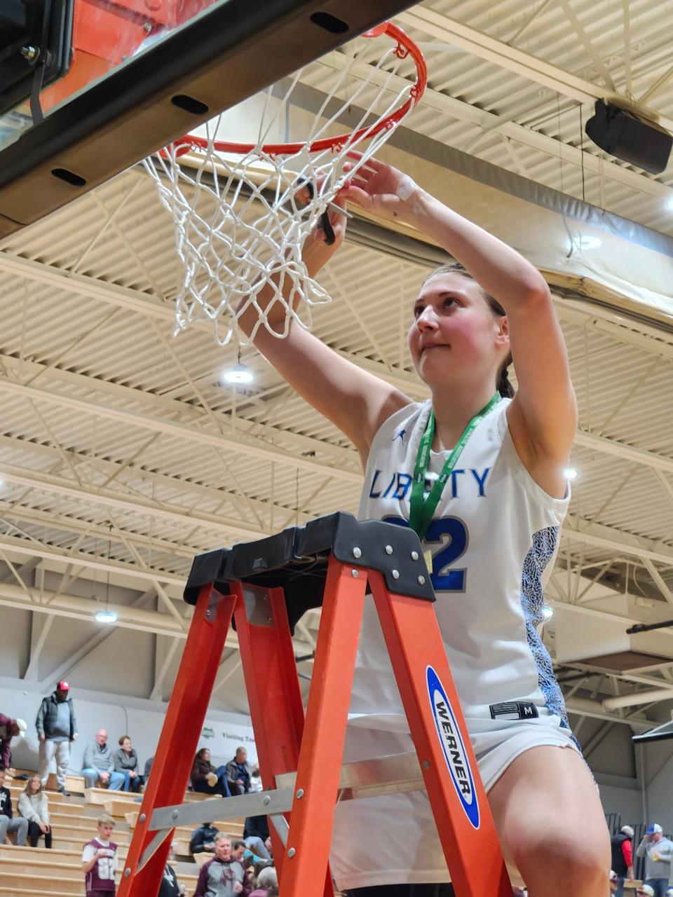 Olentangy Liberty's Gigi Bower cuts down a piece of the net after the Patriots held off Canal Winchester 60-53 in a Division I district final Saturday at Ohio Dominican.