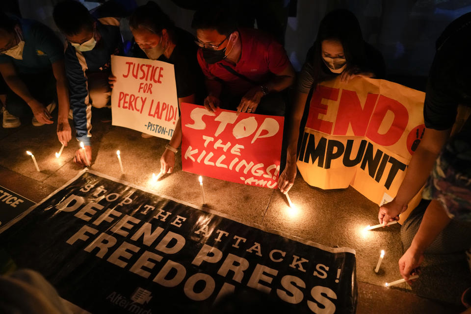 Activists light candle beside slogans as they condemn the killing of Filipino journalist Percival Mabasa during a rally in Quezon city, Philippines on Tuesday Oct. 4, 2022. Motorcycle-riding gunmen killed a longtime radio commentator in metropolitan Manila in the latest attack on a member of the media in the Philippines, considered one of the world's most dangerous countries for journalists. (AP Photo/Aaron Favila)