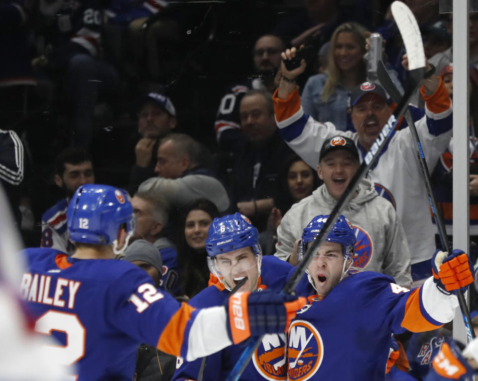 New York Islanders center Jean-Gabriel Pageau (44) celebrates with Islanders defenseman Ryan Pulock (6) and right wing Josh Bailey (12) after scoring his first goal as an Islander during the second period of an NHL hockey game against the New York Rangers, Tuesday, Feb. 25, 2020, in Uniondale, N.Y. (AP Photo/Kathy Willens)