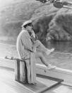 <p>Greta Garbo looks out on the horizon while relaxin on the deck of a boat. The film star is dressed casually in an oversized trench coat and sailor's cap. </p>