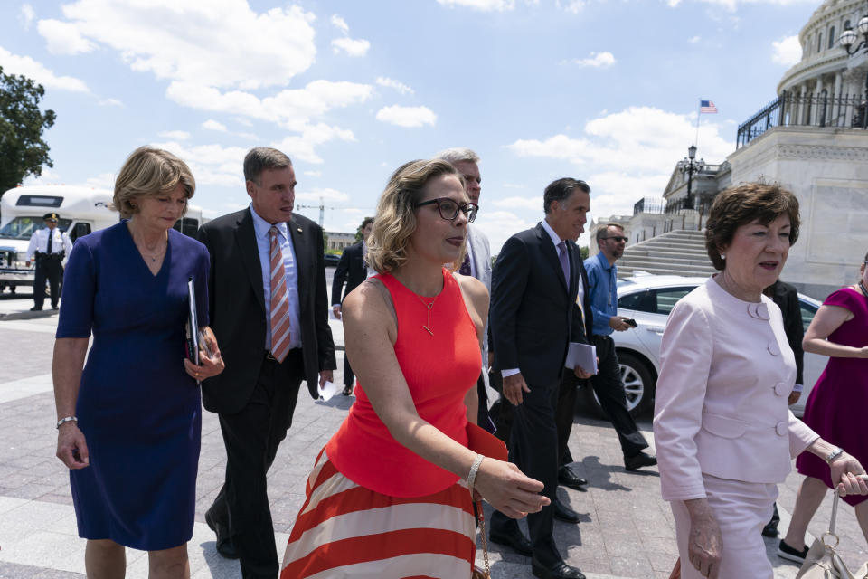 Sen. Lisa Murkowski, R-Alaska, Sen. Mark Warner, D-Va., Sen. Kyrsten Sinema, D-Ariz., Sen. Mitt Romney, R-Utah, Sen. Susan Collins, R-Maine, right, and others, return to the Capitol after a meeting with President Joe Biden at the White House in Washington, Thursday, June 24, 2021. A bipartisan group of lawmakers have negotiated a plan to pay for an estimated $1 trillion compromise plan. (AP Photo/Alex Brandon)