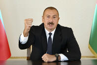 In this photo provided by the Azerbaijan's Presidential Press Office provided on Sunday, Sept. 27, 2020, Azerbaijani President Ilham Aliyev gestures as he addresses the nation in Baku, Azerbaijan. Fighting between Armenia and Azerbaijan broke out Sunday around the separatist region of Nagorno-Karabakh and the Armenian Defense Ministry said two Azerbaijani helicopters were shot down. Ministry spokeswoman Shushan Stepanyan also said Armenian forces hit three Azerbaijani tanks. (Azerbaijani Presidential Press Office via AP)