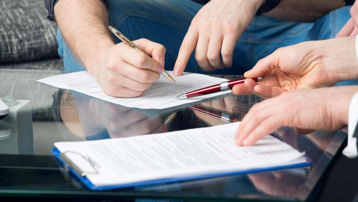 man signing paper for power of attorney