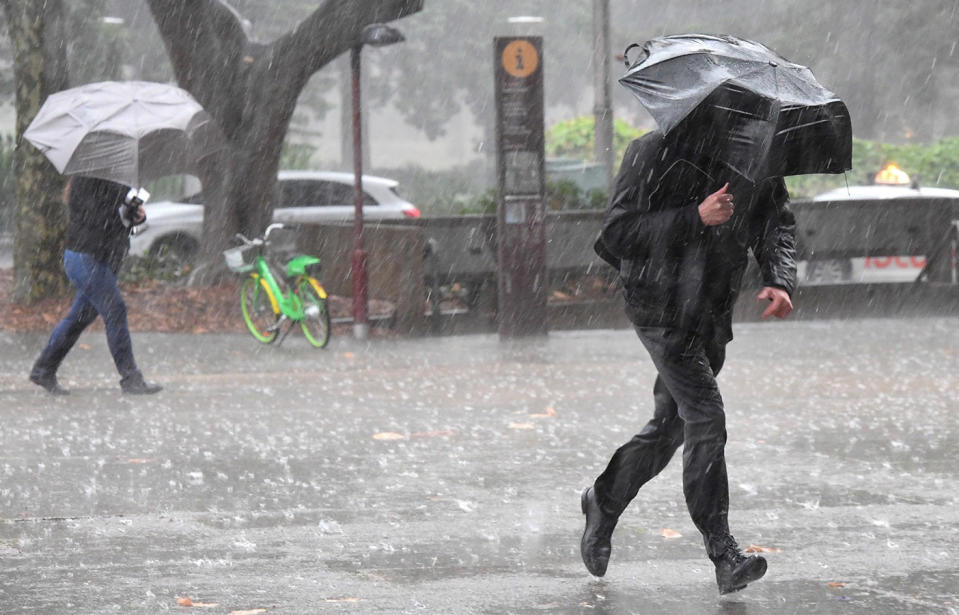 Pedestrians hold umbrellas as they walk in heavy rain in Sydney's CBD, mid-June, 2019.