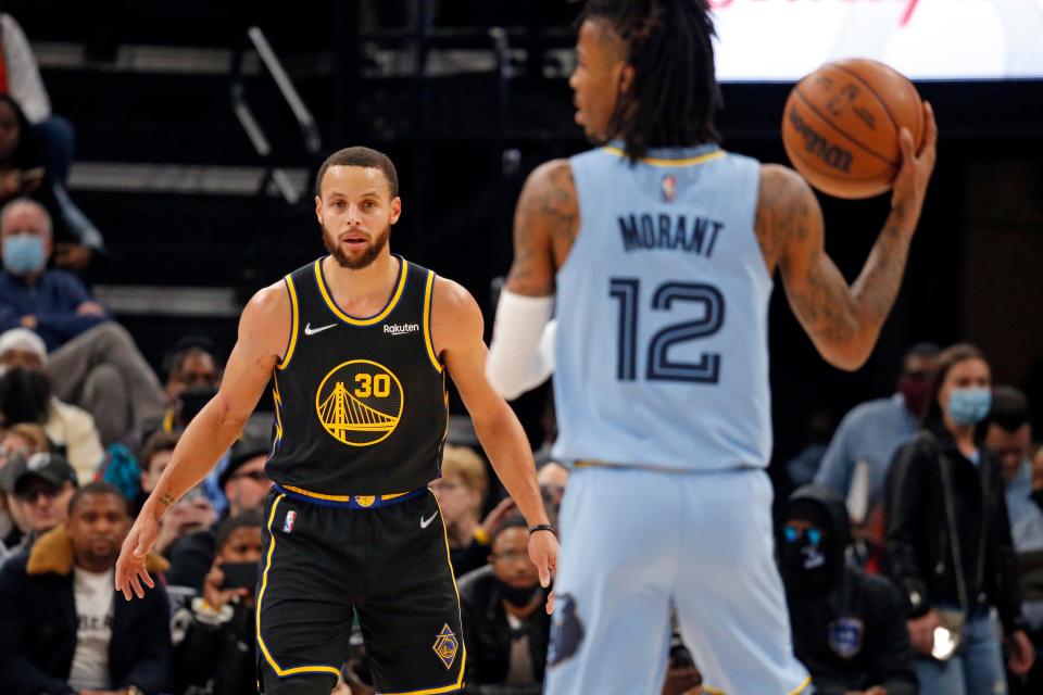 Warriors guard Stephen Curry (30) watches as Memphis Grizzles guard Ja Morant (12) brings the ball up the court during the first half at FedExForum.