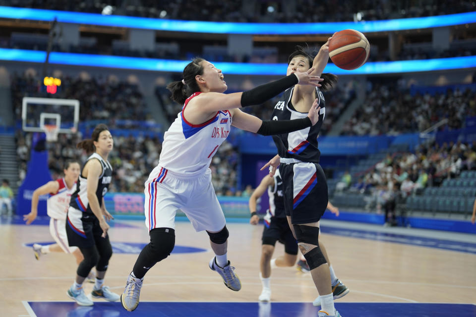 South Korea's forward Kim Danbi (13) blocks as shot by North Korea's center Ro Sukyong (12) during the women's basketball bronze medal match between North Korea and South Korea at the 19th Asian Games in Hangzhou, China, Thursday, Oct. 5, 2023. (AP Photo/Lee Jin-man)