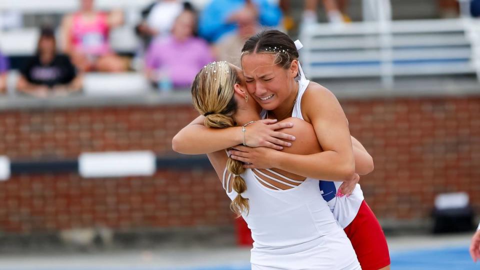 Paul Laurence Dunbar’s Keira Antoni gets a bear hug from teammate Isabela Haggard after Antoni won the 300-meter hurdles.