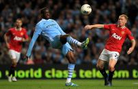 Manchester City's Gnegneri Toure Yaya and Manchester United's Paul Scholes (right) battle for the ball