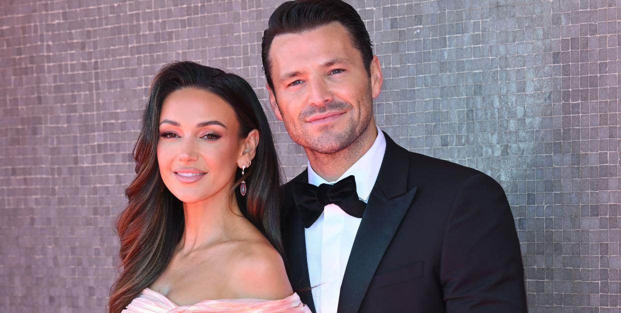 michelle keegan and mark wright standing together on the red carpet at the bafta awards 2022