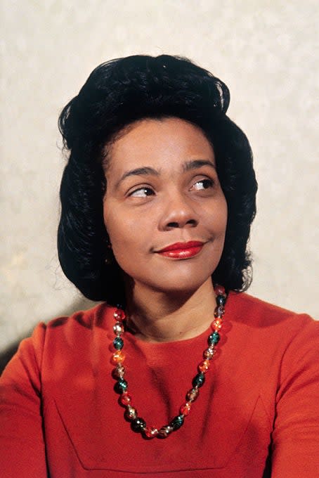 Portrait of Coretta Scott King wearing a red dress and a pearl necklace