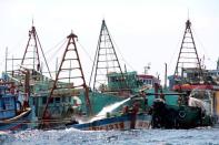 FILE PHOTO: Workers fill Vietnamese fishing boats with water to sink them after they were seized due to illegal fishing in Indonesia's waters, at Datuk island in West Kalimantan