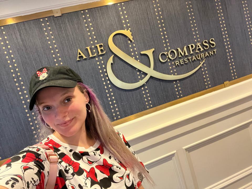 jenna posing with ale and compass sign at yacht club resort in disney world