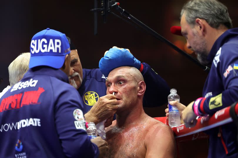 Britain's Tyson Fury (C) receives medical attention from his team