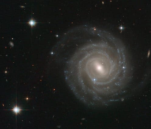 <span class="caption">The barred spiral galaxy UGC 12158.</span> <span class="attribution"><a class="link " href="https://en.wikipedia.org/wiki/Barred_spiral_galaxy#/media/File:UGC_12158.jpg" rel="nofollow noopener" target="_blank" data-ylk="slk:Wikimedia;elm:context_link;itc:0;sec:content-canvas">Wikimedia </a>, <a class="link " href="http://creativecommons.org/licenses/by-sa/4.0/" rel="nofollow noopener" target="_blank" data-ylk="slk:CC BY-SA;elm:context_link;itc:0;sec:content-canvas">CC BY-SA</a></span>