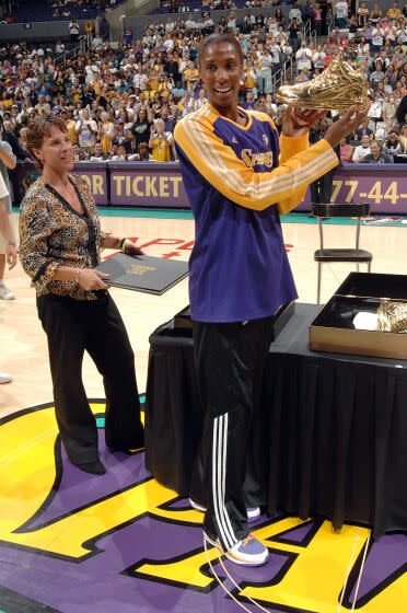 Nike representative Ilene Hauser presents Sparks star Lisa Leslie with gold shoes during a farewell ceremony in 2009.