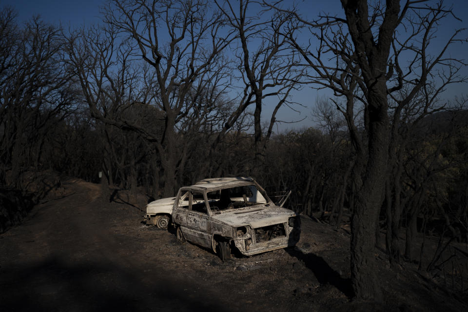 Cars burnt by wildfires are pictured in Val de Gilly, southern France, Thursday, Aug. 19, 2021. A fire that has ravaged forests near the French Riviera for four days is slowing down as winds and hot weather subside, but more than 1,100 firefighters were still struggling to get it under control Thursday, local authorities said. (AP Photo/Daniel Cole)