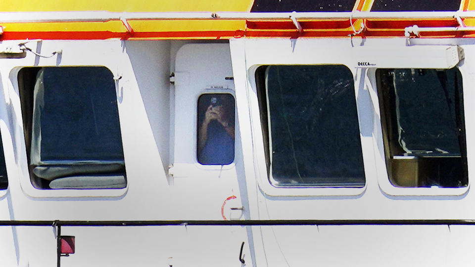 A crew member on the vessel Bear, flagged in Belgium, photographs the U.S.-based vessel Jones Act Enforcer, Tuesday, July 11, 2023, off the coast of Rhode Island. The trade association that represents the offshore service industry is going to great lengths to make sure that jobs go to Americans as the U.S. offshore wind industry ramps up. (AP Photo/Charles Krupa)