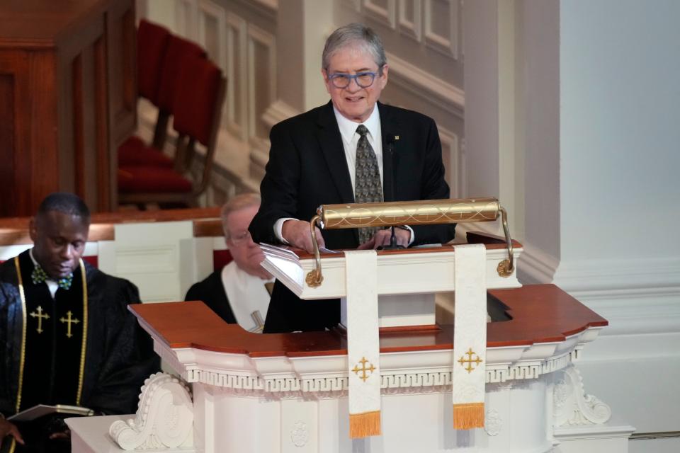 A photo of James "Chip" Carter speaking during a tribute service for former first lady Rosalynn Carter.