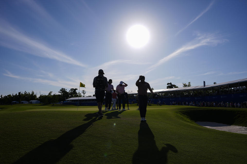 Kurt Kitayama, foreground, and Shane Lowry, of Ireland, behind, wipe their heads after finishing their day on the 18th hole during the first round of the PGA Zurich Classic golf tournament at TPC Louisiana in Avondale, La., Thursday, April 25, 2024. (AP Photo/Gerald Herbert)